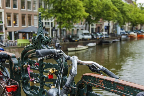 Amsterdam, Netherlands, on July 7, 2014. Bicycles on the bank of the channel. The bicycle is very popular type of transport in Holland — Stock Photo, Image