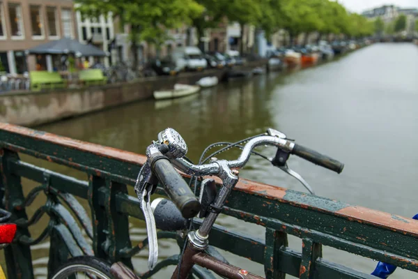 Ámsterdam, Países Bajos, 7 de julio de 2014. Bicicletas en la orilla del canal. La bicicleta es un tipo de transporte muy popular en Holanda — Foto de Stock