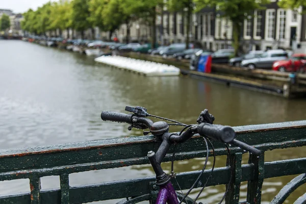 Amsterdam, Netherlands, on July 7, 2014. Bicycles on the bank of the channel. The bicycle is very popular type of transport in Holland — Stock Photo, Image