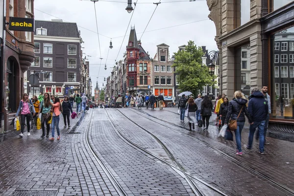 Амстердам, Нидерланды, 7 июля 2014 года. Туристы и горожане идут по улице в дождливую погоду — стоковое фото