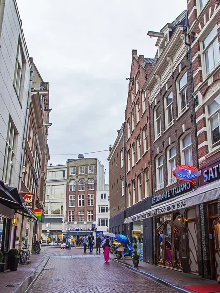 Amszterdam, Hollandia, július 7-én 2014-re. turisták és a polgárok menni az utcán esős Időjárás — Stock Fotó
