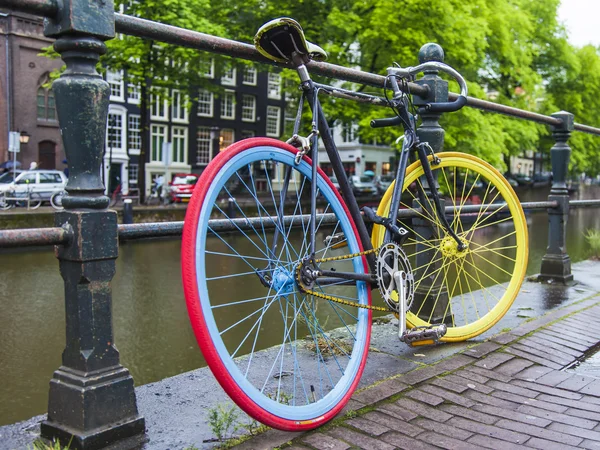 Ámsterdam, Países Bajos, 10 de julio de 2014. Las bicicletas están aparcadas en la calle de la ciudad a orillas del canal — Foto de Stock