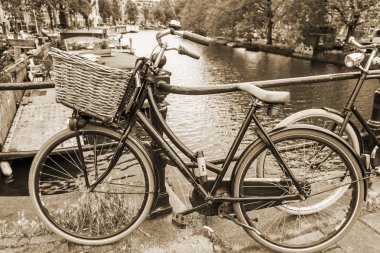 Amsterdam, Hollanda, üzerinde 10 Temmuz 2014. Bisiklet kanal kıyısında şehrin cadde üzerinde park edilmiş