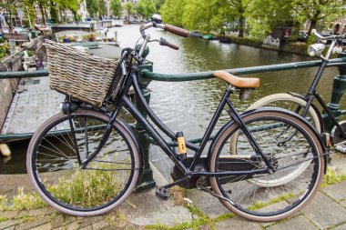 Amsterdam, Hollanda, üzerinde 10 Temmuz 2014. Bisiklet kanal kıyısında şehrin cadde üzerinde park edilmiş