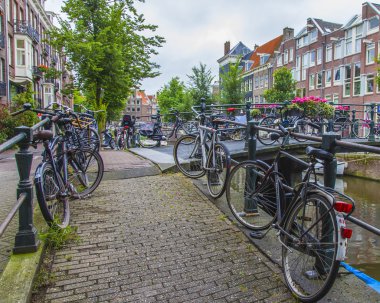 Amsterdam, Hollanda, üzerinde 10 Temmuz 2014. Bisiklet kanal kıyısında şehrin cadde üzerinde park edilmiş