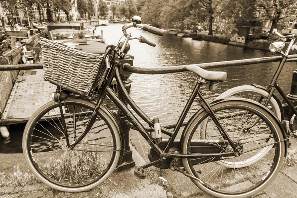 Amsterdam, Netherlands, on July 10, 2014. Bicycles are parked on the city street on the bank of the channel — Stock Photo, Image