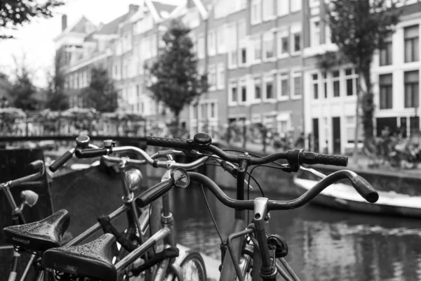 Ámsterdam, Países Bajos, 10 de julio de 2014. Las bicicletas están aparcadas en la calle de la ciudad a orillas del canal —  Fotos de Stock