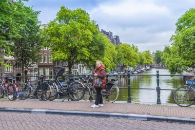 Amsterdam, Hollanda, üzerinde 10 Temmuz 2014. Bisiklet kanal kıyısında şehrin cadde üzerinde park edilmiş