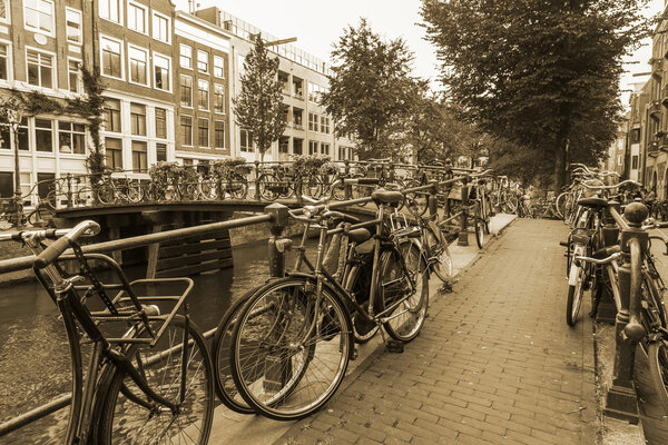 Amsterdam, Netherlands, on July 10, 2014. Bicycles are parked on the city street on the bank of the channel