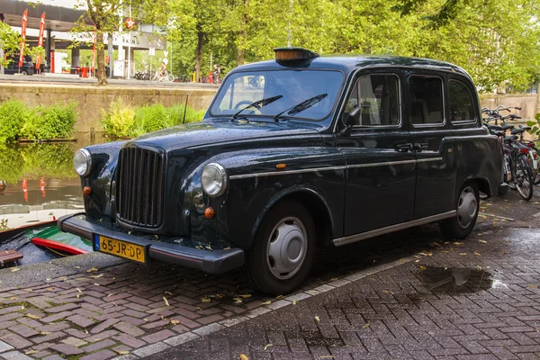 Amsterdam, Nederländerna. Den vackra bil parkerad på packa ihop av kanalen — Stockfoto