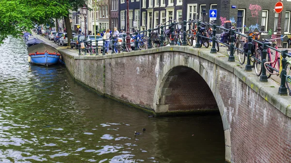 2014 年 7 月 10 日に、オランダのアムステルダム。チャネルの銀行に車を停めて自転車 — ストック写真