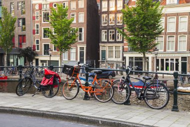 Amsterdam, Hollanda, üzerinde 10 Temmuz 2014. Bisiklet kanal kıyısında şehrin cadde üzerinde park edilmiş