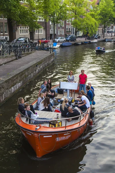 Amsterdam, Paesi Bassi, il 10 luglio 2014. Barca a piedi si muove lungo la costa del canale — Foto Stock