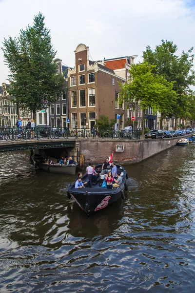 Ámsterdam, Países Bajos, 10 de julio de 2014. Barco a pie se mueven por el canal — Foto de Stock