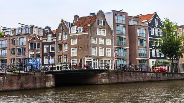 Amsterdam, Nederland, op 10 juli 2014. typisch stedelijke weergave met huizen aan de oever van het kanaal — Stockfoto