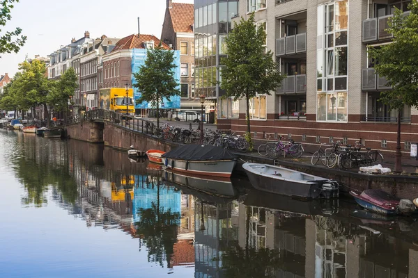 Ámsterdam, Países Bajos, 10 de julio de 2014. Típica vista urbana con edificios antiguos en la orilla del canal y barcos amarrados en la orilla — Foto de Stock