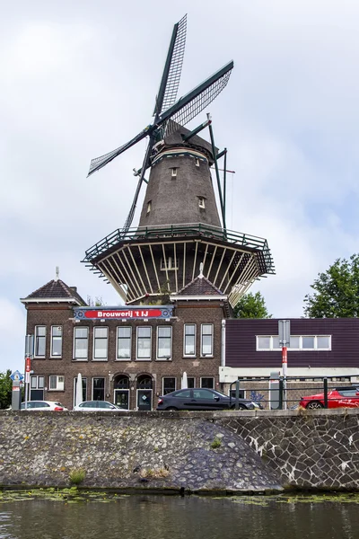 Ámsterdam, Países Bajos, 10 de julio de 2014. Vista de la orilla del río Amstel. Molino Vintage — Foto de Stock