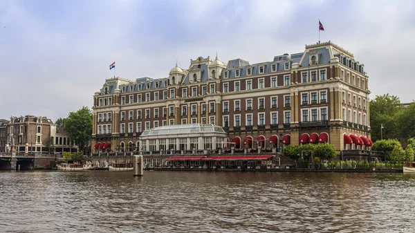 Amsterdam, Paesi Bassi, il 10 luglio 2014. Vista della riva del fiume Amstel. Mulino vintage — Foto Stock