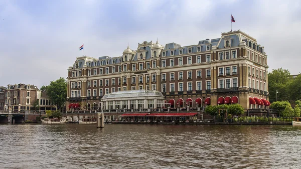 Amsterdam, Netherlands, on July 10, 2014. View of the river bank Amstel. Vintage mill — Stock Photo, Image