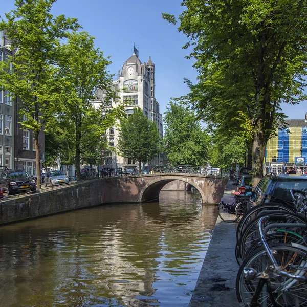 Ámsterdam, Países Bajos, 10 de julio de 2014. Una típica vista urbana con edificios antiguos a orillas del canal — Foto de Stock