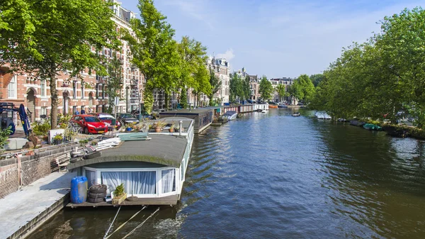 Amsterdam, Nederländerna, den 10 juli 2014. bebodda båtar på segla utmed kusten av kanal — Stockfoto