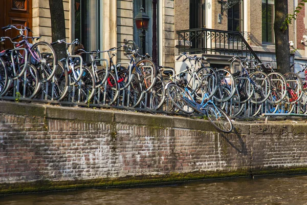 Amsterdam, Nederländerna, den 10 juli 2014. cyklarna parkerade på packa ihop av kanalen — Stockfoto