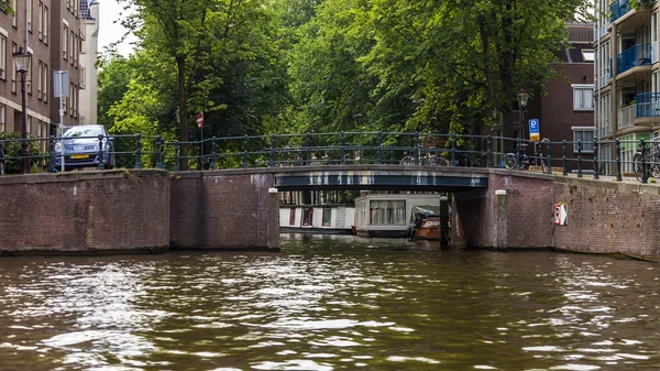 Amsterdam, Nederland, op 10 juli 2014. typisch stedelijke weergave met oude gebouwen aan de oever van het kanaal — Stockfoto