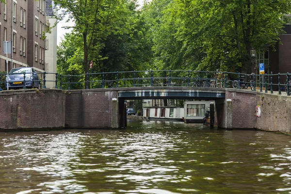 Amsterdam, Nederländerna, den 10 juli 2014. typiska urban Visa med gamla byggnader på packa ihop av kanalen — Stockfoto