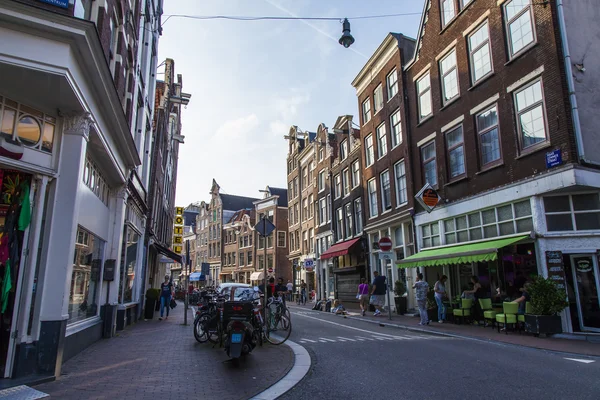 Amsterdam, Nederland, op 10 juli 2014. typisch stedelijke weergave met oude gebouwen aan de oever van het kanaal — Stockfoto