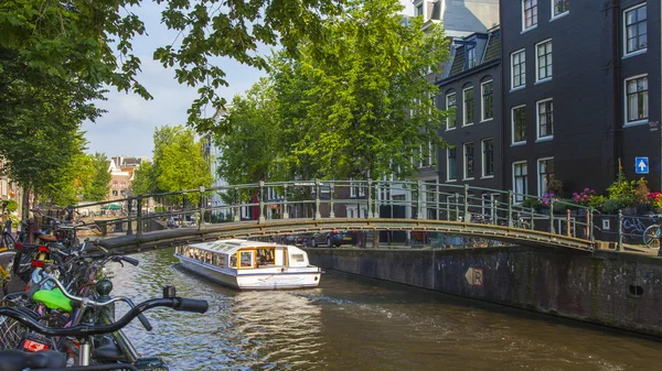 Amsterdam, Nederland, op 10 juli 2014. typisch stedelijke weergave met oude gebouwen aan de oever van het kanaal — Stockfoto