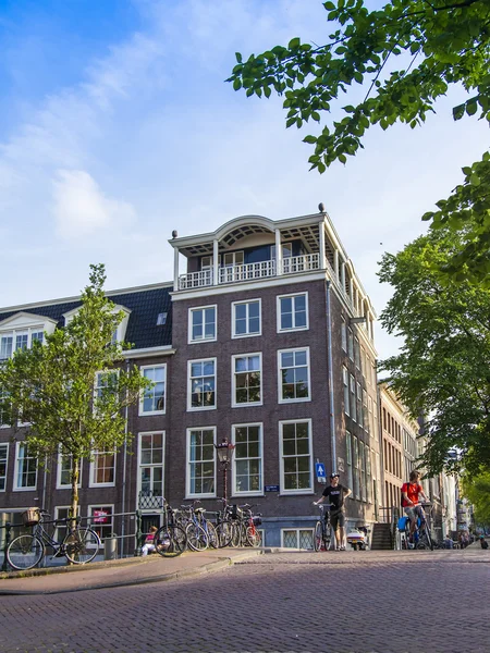 Amsterdã, Holanda, em 10 de julho de 2014. Vista urbana típica com edifícios antigos na margem do canal — Fotografia de Stock