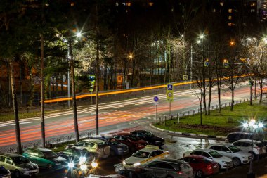 Pushkino, Rusya, 5 Kasım 2021. Akşam şehir manzarası. Arabalar karanlık sokaklar boyunca gider.