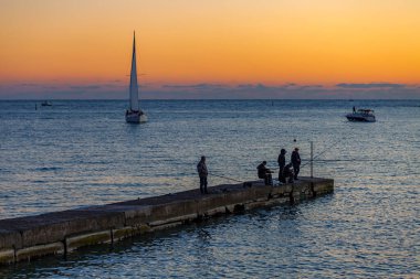 Sochi, Rusya, 13 Nisan 2021. Gün batımında deniz manzarası. Ufuktaki yelkenli