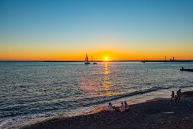 Sochi, Rusya, 20 Ekim 2021. Gün batımında deniz manzarası. Ufuktaki yelkenli