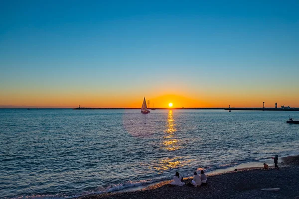 Sochi, Rusya, 20 Ekim 2021. Gün batımında deniz manzarası. Ufuktaki yelkenli