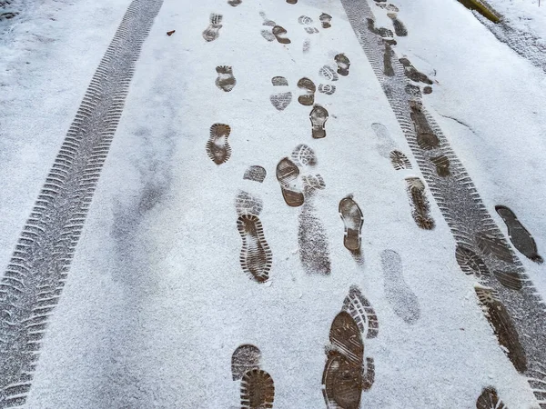 Footprints of boots on a track covered with snow in winter