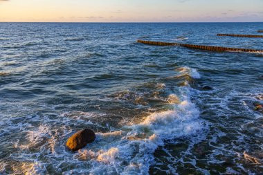 Deniz manzarası. Gün batımında dalgalar ve köpüklerle sörf yapmak. Doğa arkaplanı