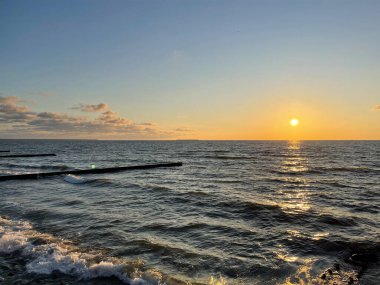 Deniz manzarası. Gün batımında dalgalar ve köpüklerle sörf yapmak. Doğa arkaplanı
