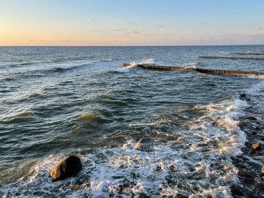 Deniz manzarası. Gün batımında dalgalar ve köpüklerle sörf yapmak. Doğa arkaplanı
