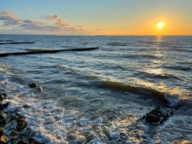 Deniz manzarası. Gün batımında dalgalar ve köpüklerle sörf yapmak. Doğa arkaplanı