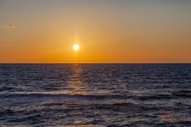 Deniz manzarası. Gün batımında dalgalar ve köpüklerle sörf yapmak. Doğa arkaplanı