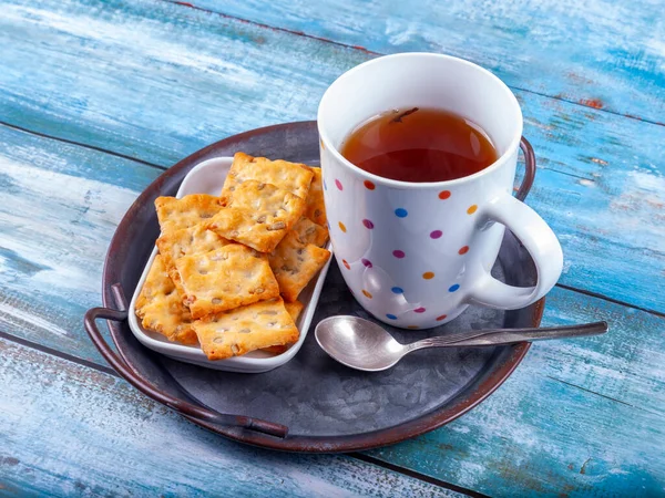 ヴィンテージプレートの上にお茶と食事の風味豊かなビスケットのカップ ストックフォト