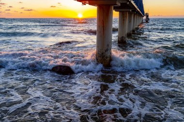 Deniz manzarası. Gün batımında dalgalar ve köpüklerle sörf yapmak. Doğa arkaplanı