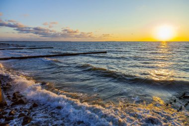 Deniz manzarası. Gün batımında dalgalar ve köpüklerle sörf yapmak. Doğa arkaplanı
