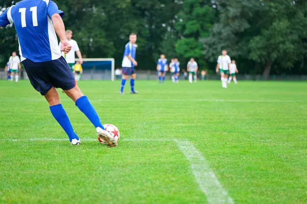 Jogador de futebol chuta a bola. Imagem horizontal da bola de futebol wi — Fotografia de Stock