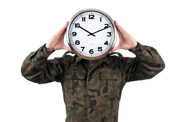 Soldat avec horloge analogique sur le visage. Concept de date limite isolé sur fond blanc . Photo De Stock