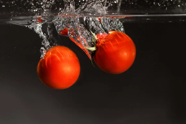掉进水里的新鲜番茄 — 图库照片