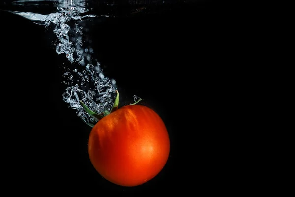 Fresh tomato dropped into water — Stock Photo, Image