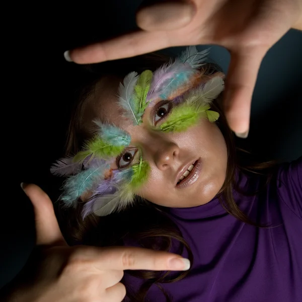 Girl with colorful feather on her face — Stock Photo, Image