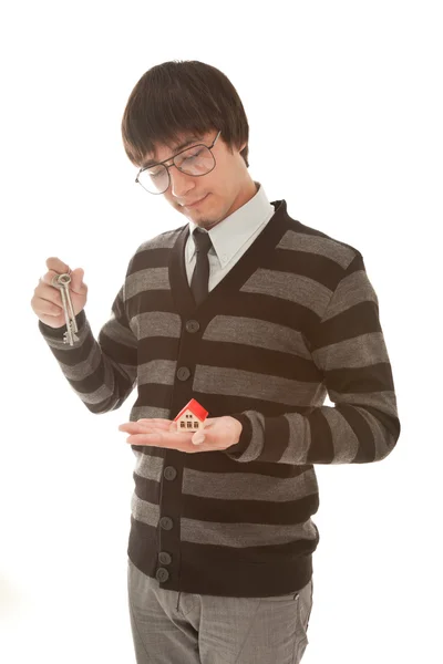 Бизнесмен с игрушечным домиком и ключами в руках — стоковое фото